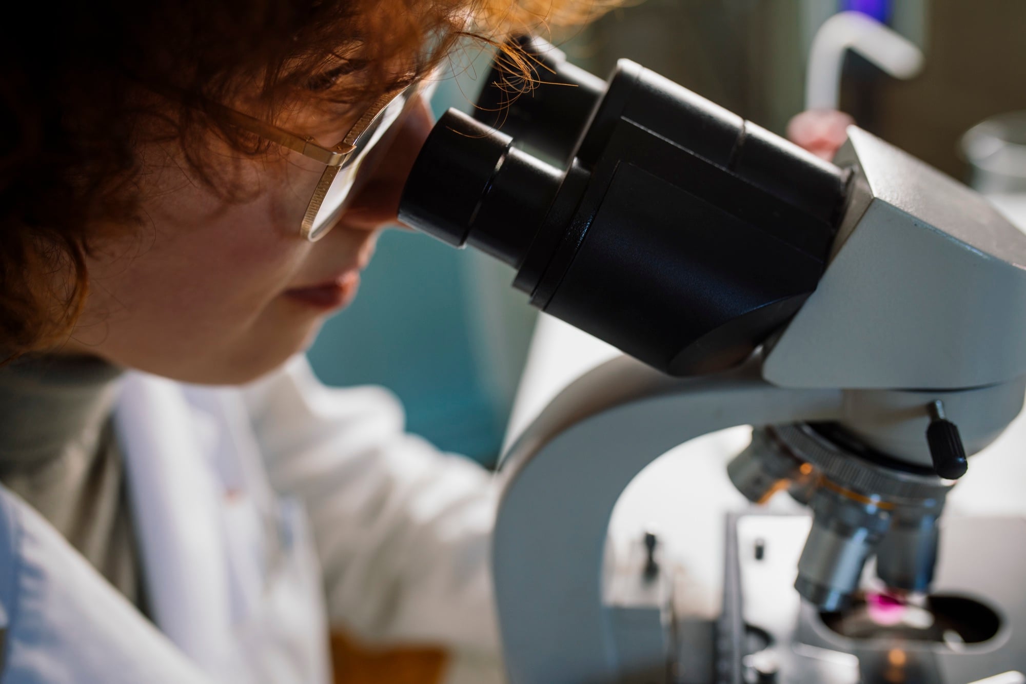 Researcher examining a sample through a microscope