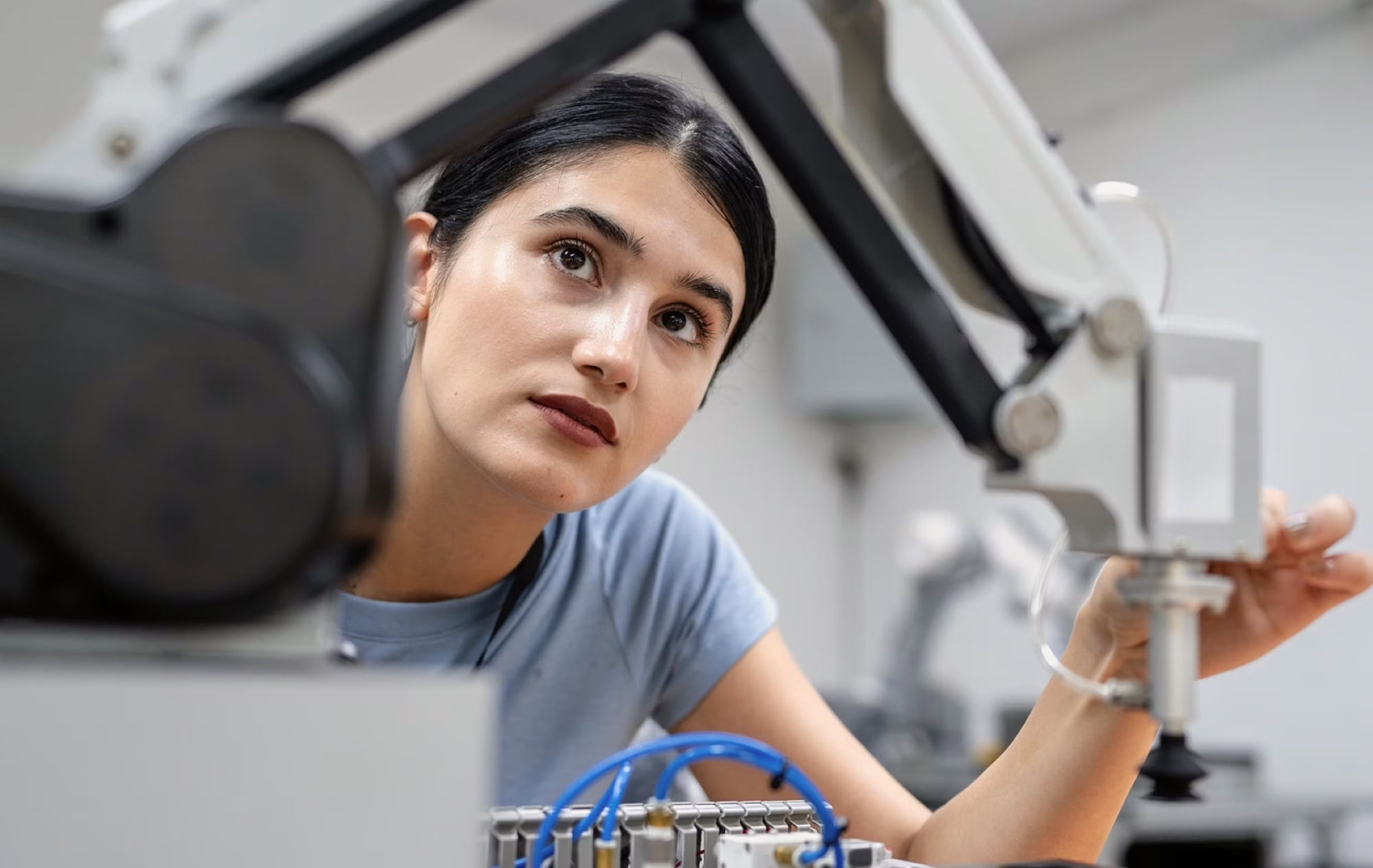 Engineer inspecting robotic equipment up close